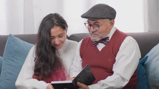 abuelo con su bella nieta en casa leyendo una historia felices y tranquilos 