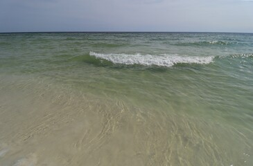 A wave from the ocean goes to the shore