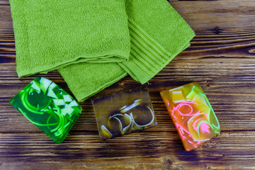 Pieces of the handmade soap and towel on wooden background. Top view