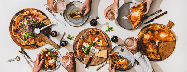 Pizza party for friends. Flat-lay of various pizzas, lager beer and peoples hands with pizza slices and glasses over white table background, top view. Fast food, comfort food, Italian cuisine concept - 388142569