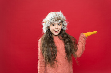 surprised kid wearing comfortable warm clothes for cold weather forecast on winter xmas holiday and vacation presenting product, surprise