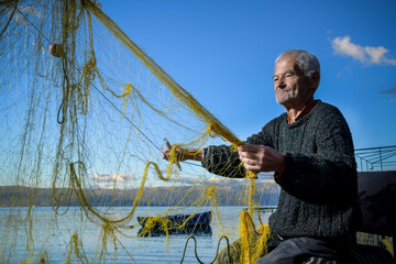A fisherman preparing the fishing net near the beach