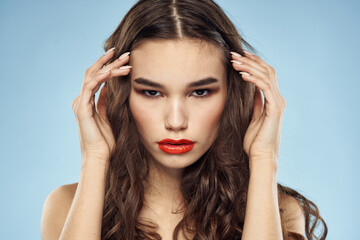 Fototapeta premium Brunette naked shoulders red lips fashionable hairstyle blue background