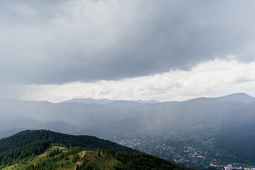 Rainfall in Karpathians mountains. Landscape of a beautiful countryside without people. Panoramic view in summer time. Advert for travel agency