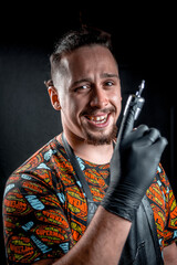 Tattoo master and a tattoo gun in tattoo studio