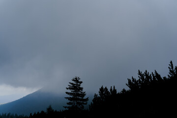 Dusk in the mountains before a storm and a thunderstorm on a rainy day. Severe weather conditions. Peaks of the Carpathian Mountains