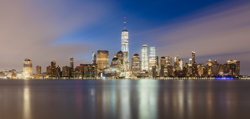 USA, New York, New York City, Lower Manhattan with One World Trade Center illuminated at dusk seen across river