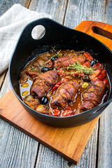 Modern Style traditionelle deutsche slow cooked German Rinderrouladenmit Gemüse und Oliven in würziger Bratensauce als close-up in einem Design Topf
