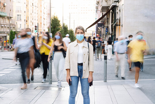 Young woman wearing mask standing on street in city
