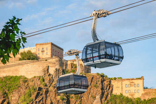 Germany, North Rhine-Westphalia, Koblenz, Overhead cable cars against Ehrenbreitstein Fortress