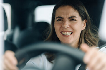 Young woman getting angry while getting stuck in traffic