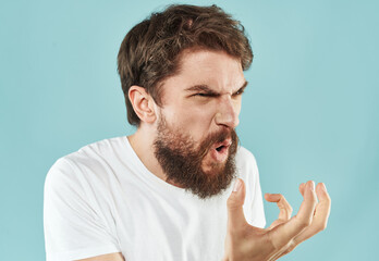 Emotional bearded man on a blue background cropped view of gesticulating with his hands