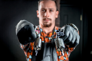 Master tattooist and a tattoo machine in a workshop studio