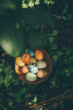 Bowl of organically colored Easter eggs lying outdoors