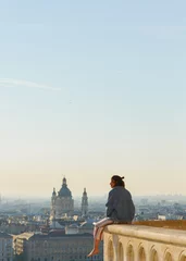 Tuinposter Girl watching the beautiful panoramic landscape and skyline of the city of Budapest from a high building. Holidays background in summer  © miranda