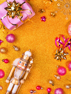 Studio shot of Christmas present, old-fashioned nutcracker and various purple colored Christmas decorations