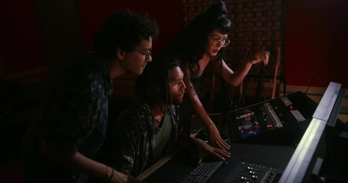 Band producing album with music producer in music studio