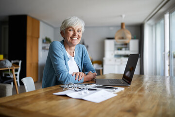 Senior woman sitting with arms crossed at home