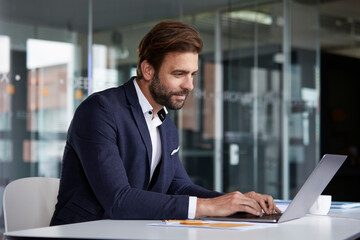 Businessman working on laptop while sitting at office