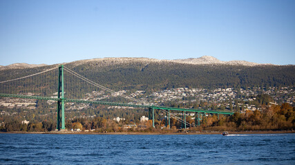 Fototapeta na wymiar A view of the Lion's Gate Bridge and the North Shore mountains in the background taken from a boat on the water. Looking at North and West Vancouver, British-Columbia