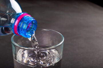 Pouring water into a glass. A cold drink prepared to be served.