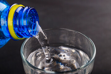 Pouring water into a glass. A cold drink prepared to be served.