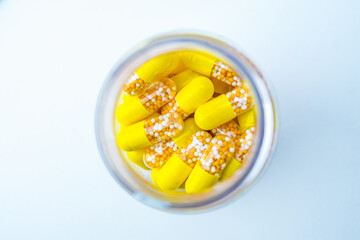 Open Container with Vitamin D3 Multivitamin capsules on white background