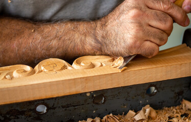 Carpenter working on wooden furniture with hand carving. Wood carving art with hand tools
