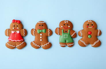 Christmas human shaped gingerbread cookies on light blue background, flat lay