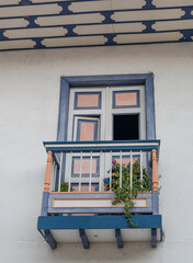 Fototapeta na wymiar Balconies and windows in red, blue, green, yellow, with gardens and flowers, in the coffee region in Colombia