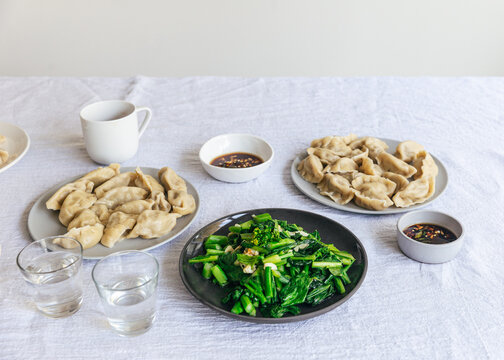 Meal of chinese dumpkings, steamed vegetables and buns