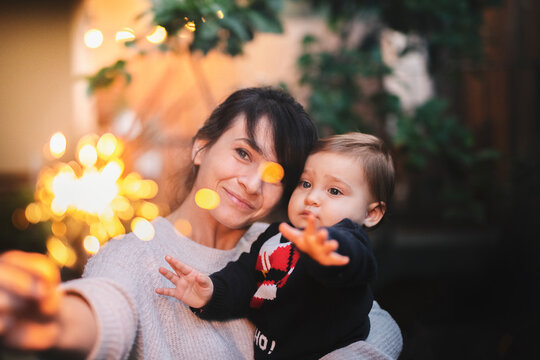 Mom and daughter having fun with sparklers at a party - Powered by Adobe