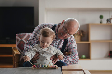 Grandfather playing on xylophone with his grandson