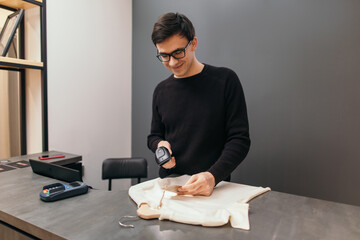 Content man with scanner working in clothing store