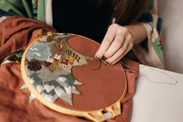 Needlewoman embroidering pattern in hoop