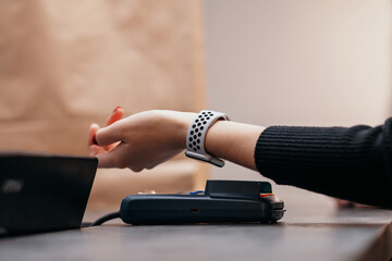 Female customer using smart watch for NFC payment in store