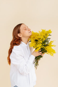 Delighted ginger female enjoying yellow flowers