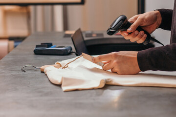 Anonymous man with scanner working in clothing store