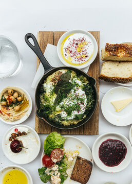 lebanese spread at restaurant with creamy hummus, eggs, green shakshuka, labaneh, zaatar, jam and bread