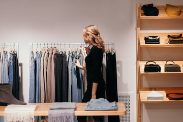 Young woman checking assortment in clothing shop