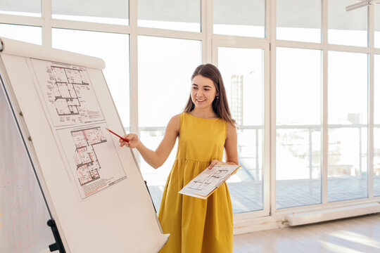 Cheerful architect showing blueprints during conference