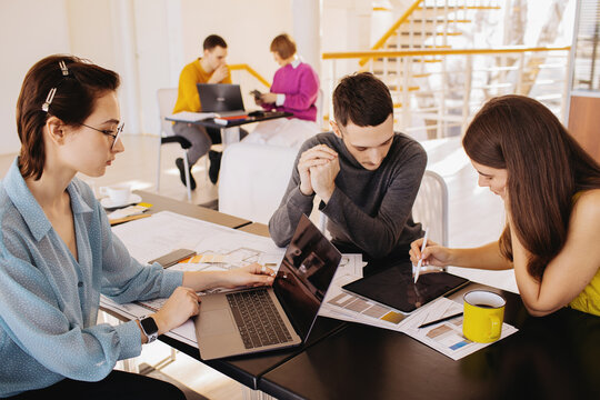 Young coworkers using gadgets in workspace