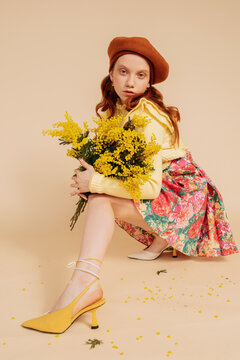 Stylish ginger woman with yellow flowers