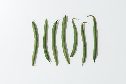 green beans organized on white background