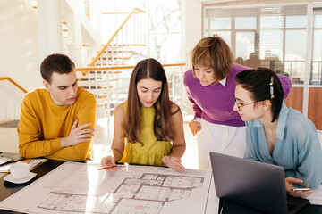 Young woman explaining draft to colleague