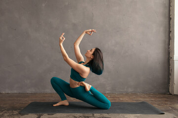 Focused female doing yoga exercise in weathered room