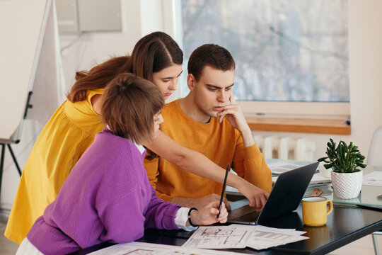 Young woman helping colleagues with project