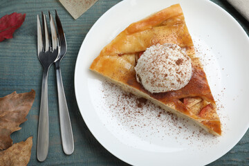 Slice of traditional apple pie with ice cream served on blue wooden table, flat lay