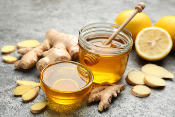 Honey, ginger and lemon on grey table. Natural cold remedies