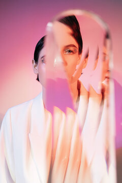 Attractive woman looking at camera through glass